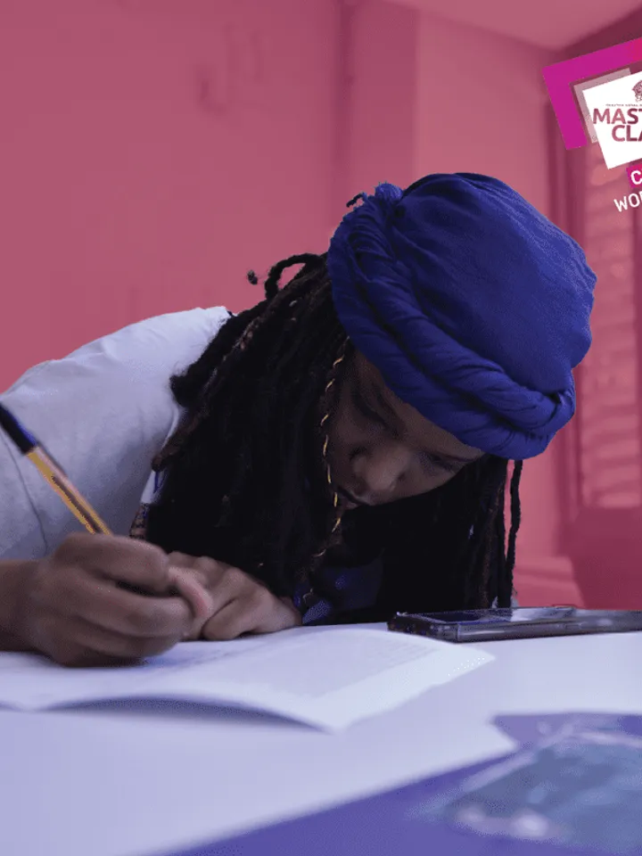 Photo of a young person writing on a script with a pen. 