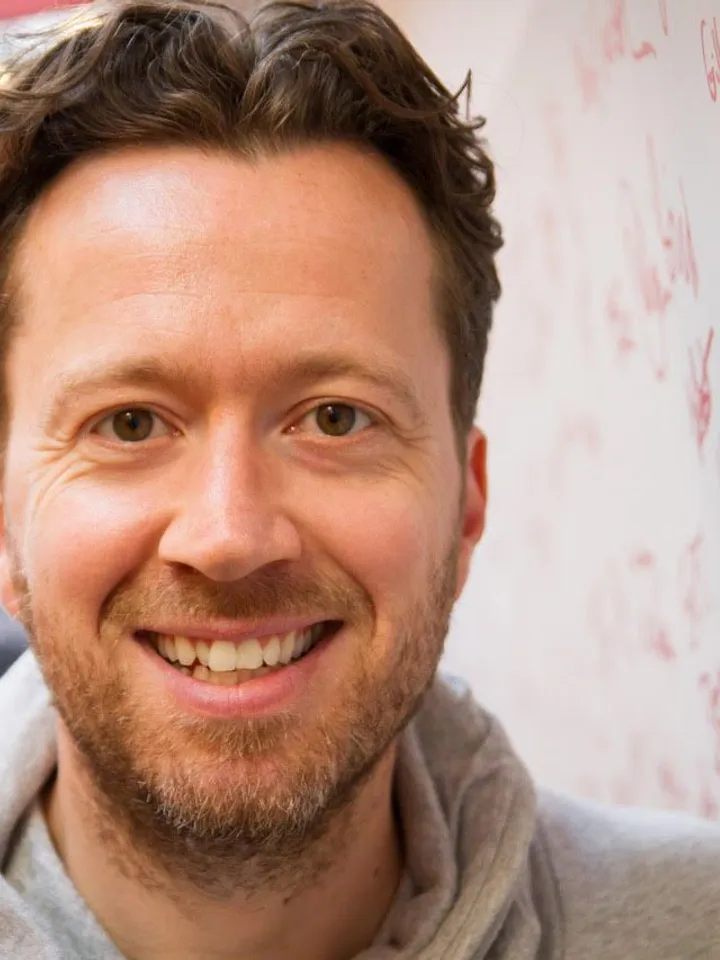 Jez Bond Headshot infront of signed wall at the Park Theatre